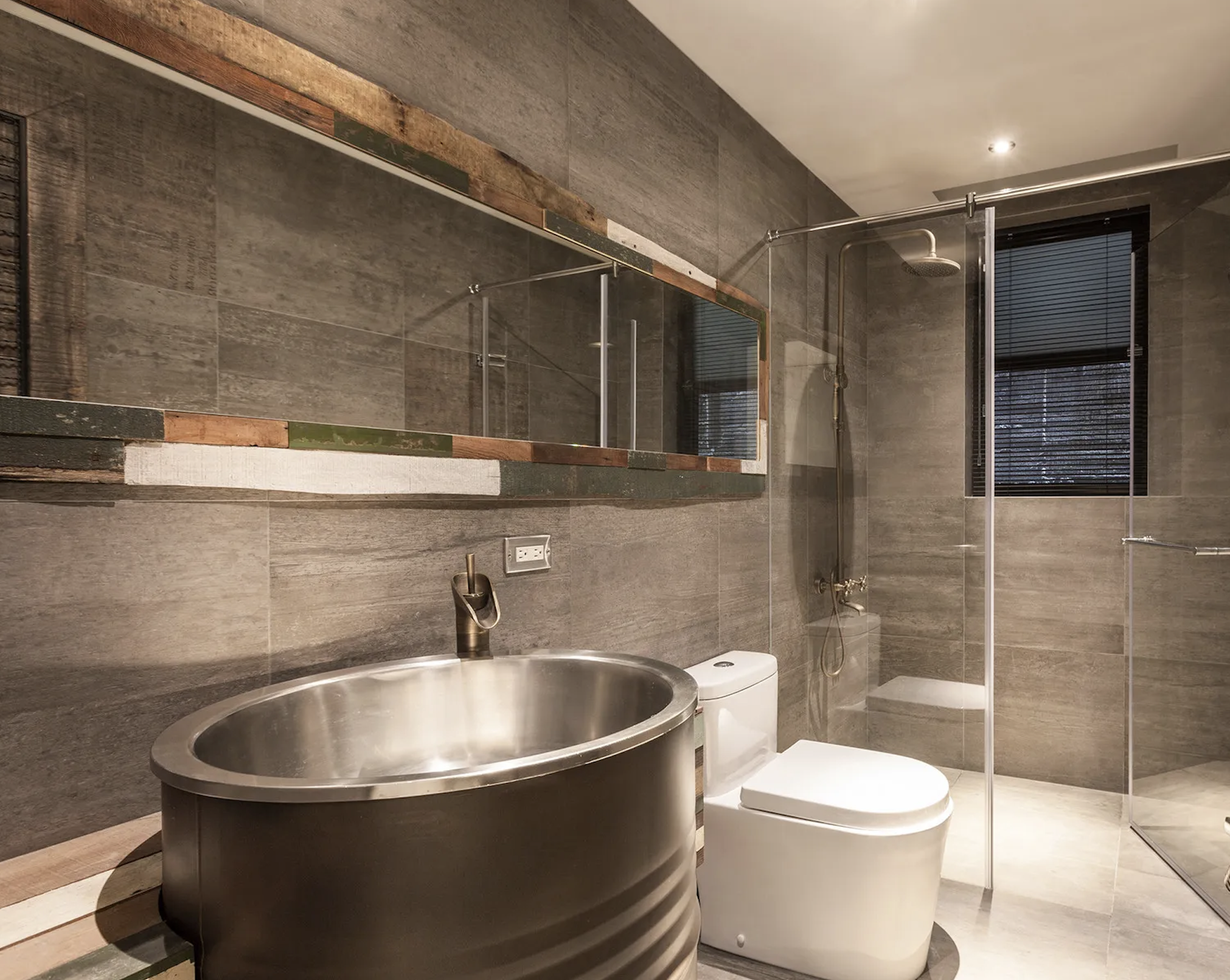 Newport Beach guest bath with large-format dark tile, glass shower, and modern fixture updates